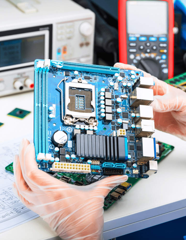 two hands holding a large electronics circuit board full of components