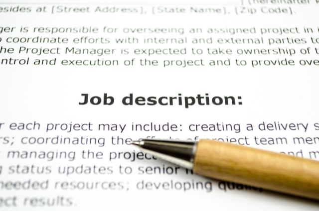 a close up of a printed up job description and a pen