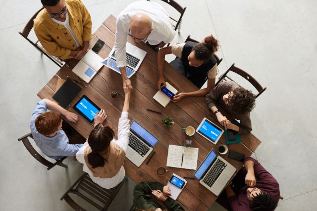 a team all sat around a table collaborating together on a project