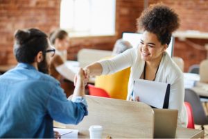 a new recruit shaking hands with an onboarding partner as part of an effective recruitment strategy