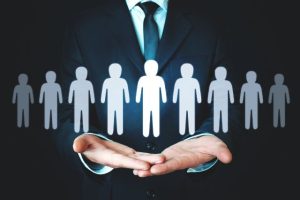 a graphic of a man in a suit with his hands in front of him holding a line of figures to represent candidates in a job search