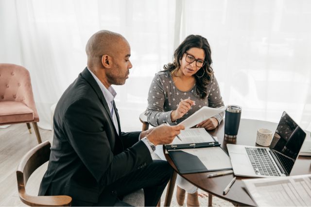 a recruitment consultant showing shortlisted candidates CVs to an employer in an office