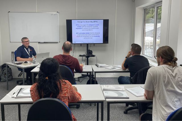 a classroom of students upskilling in electronics as a trainer presents a class