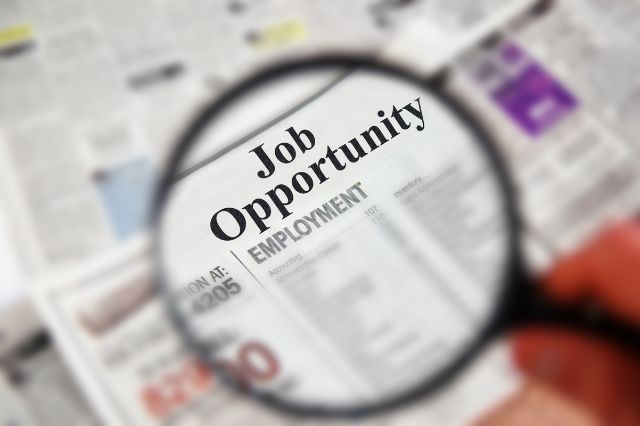 a magnifying glass over a job ad in a news paper